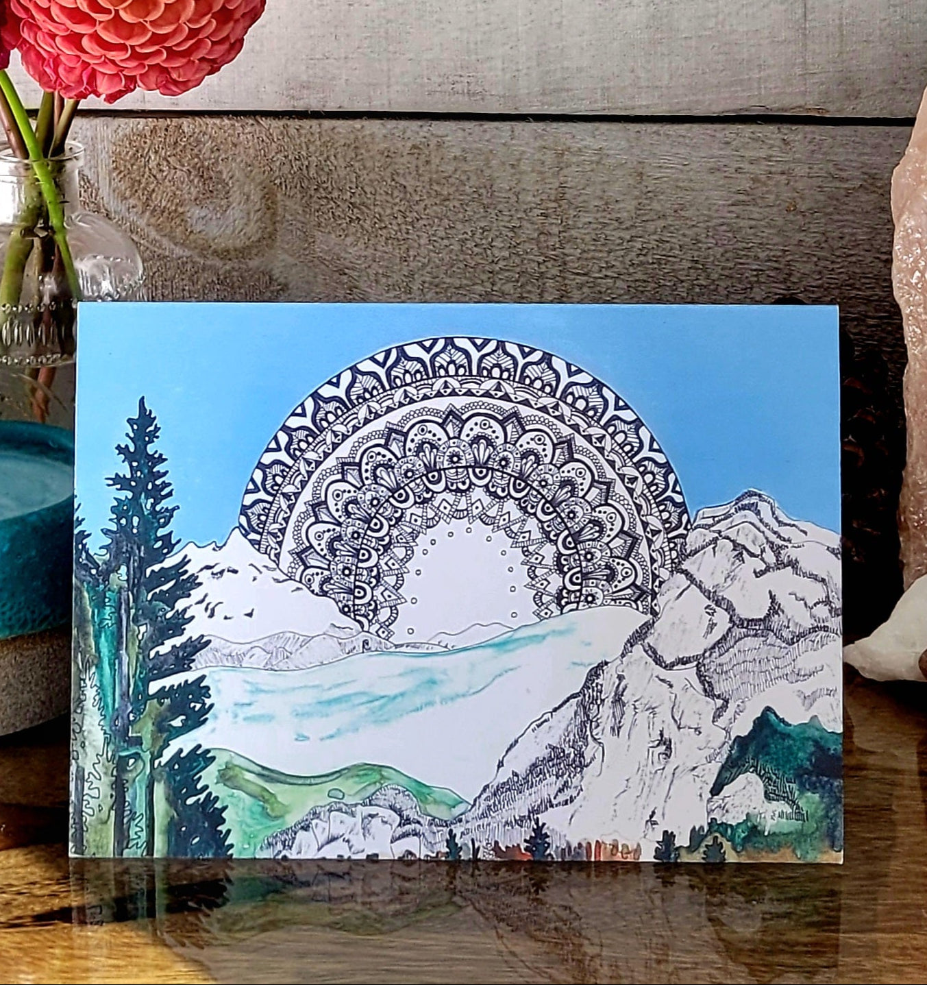Mandala design with mountain and forest scene.