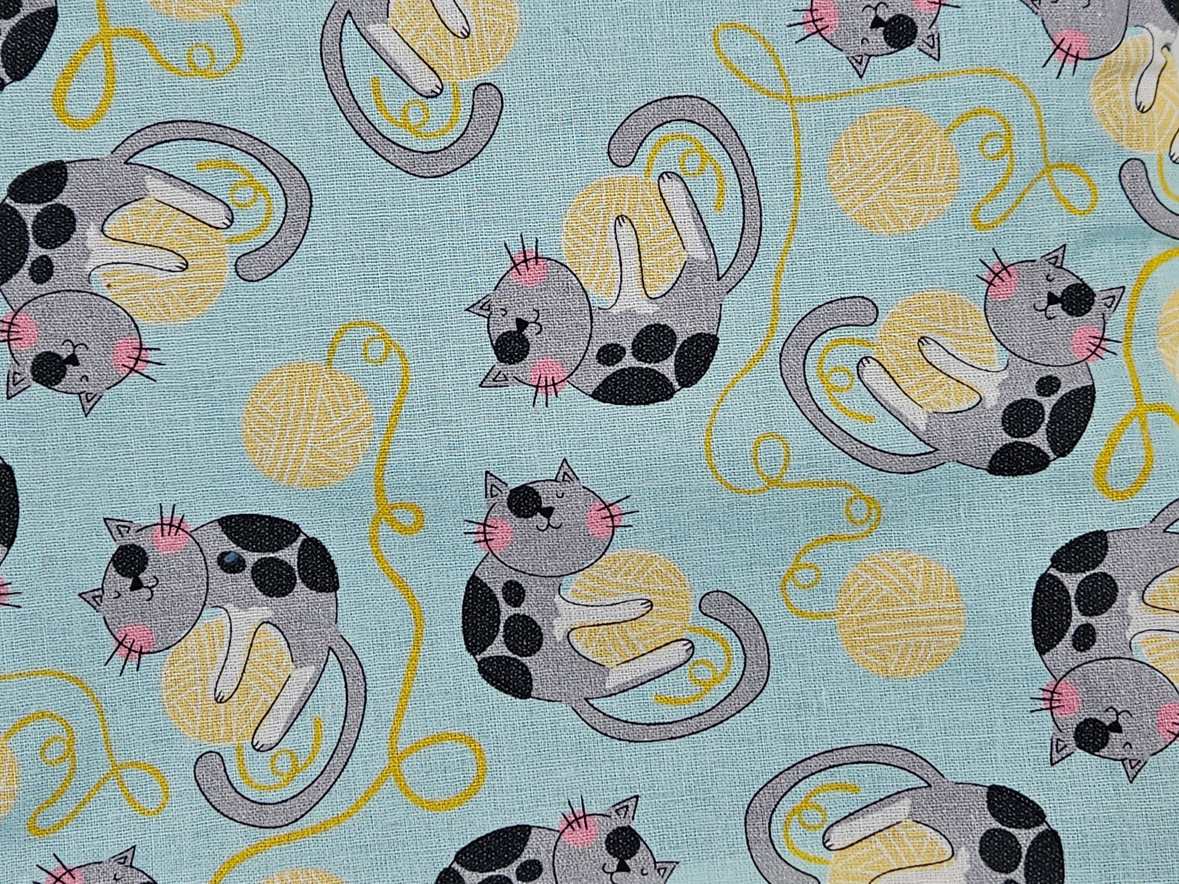 Pattern of cartoon cats and yarn balls on a blue background