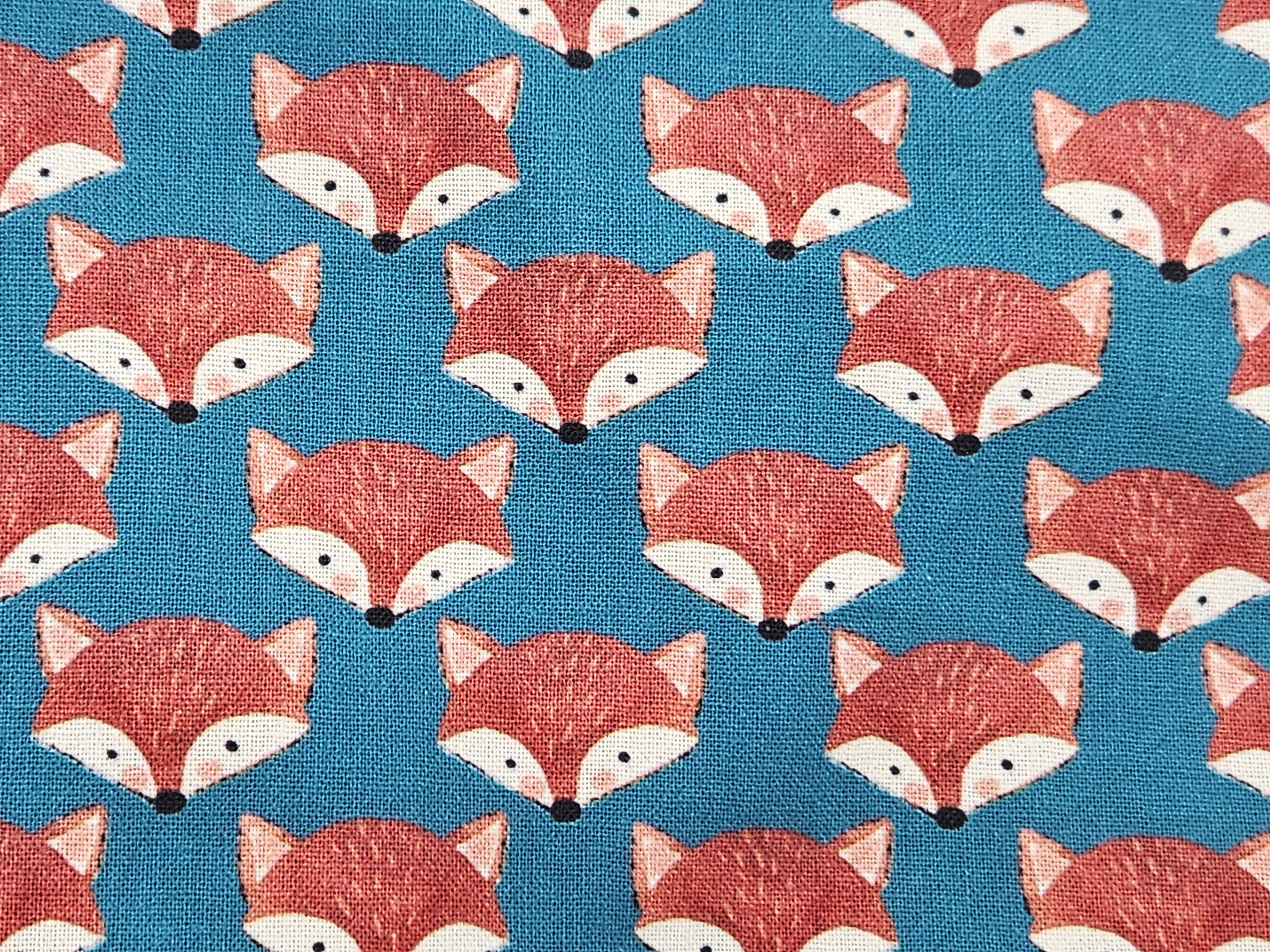Pattern of fox faces on a blue background