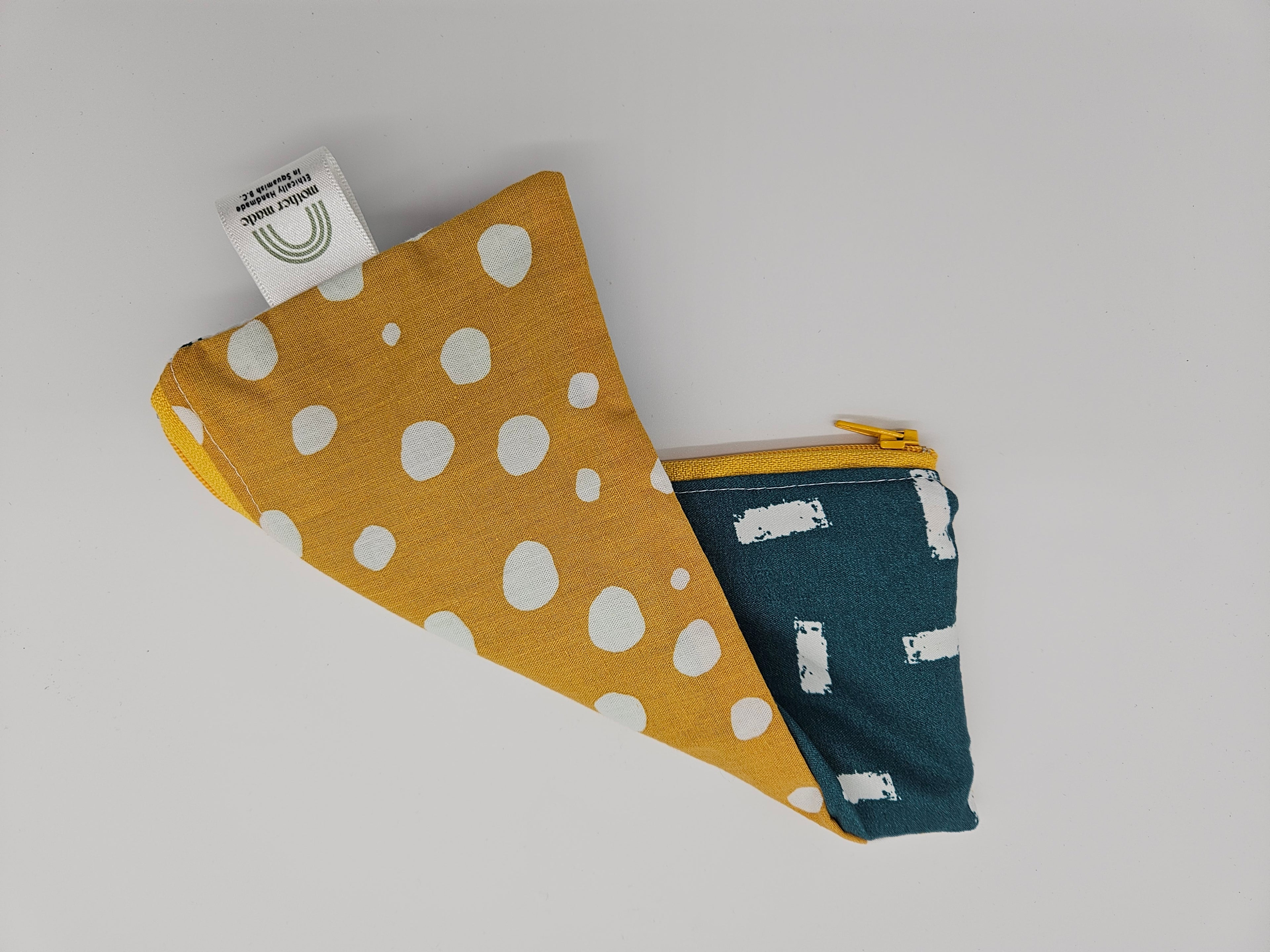 Two fabric swatches, one blue with white patterns and one yellow with white polka dots, on a light gray background.